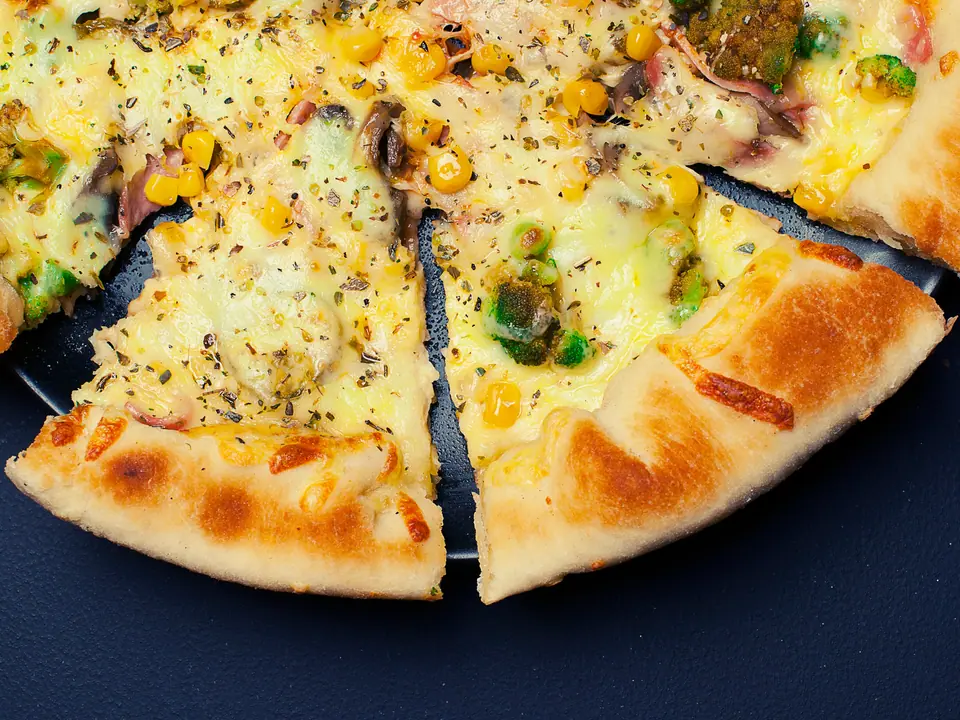 Pizza fatiada com borda dourada e queijo derretido