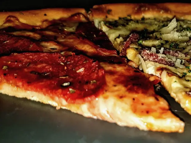 Fatias de pizza de queijo num prato escuro